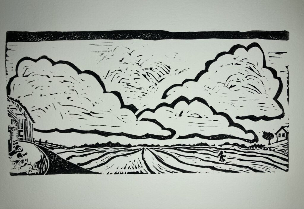 A woodcut of a field with clouds by Leigh Brownhill.